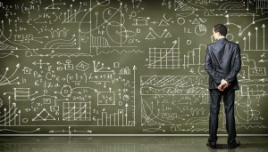 Business person standing against the blackboard with a lot of da