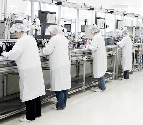 Assemblers in a clean room environment that is being monitored by particle counters.