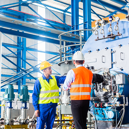 Industrial workers looking at pressure transducer in equipment.